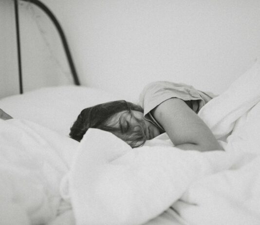 여름철 운동 후 충분한 수면의 중요성 grayscale photo of sleeping woman lying on bed