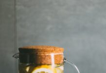 여름철 체력 유지와 정신 건강 관리법 clear glass pitcher filled with sliced lemons on black and white table runner
