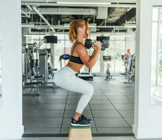 전문가들이 추천하는 허리 건강을 위한 운동 woman wearing black sports bra and white legging lifting dummbells