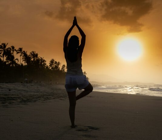스트레스 해소를 위한 간단한 운동 woman in white tank top and white shorts standing on beach during sunset