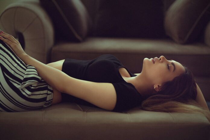 woman in black and white stripe shirt lying on brown couch