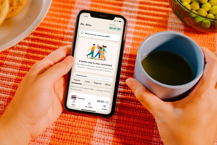 Hands holding smartphone with app, coffee cup, and food.