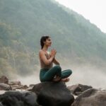 ‘하루 10분 명상’ 열풍…직장인 스트레스 관리에 소확행 찾는다 a woman sitting on top of a rock next to a river
