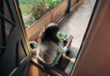 “지친 일상, 만성피로 탈출법 찾기”…작은 변화가 만드는 큰 활력 Woman sitting on balcony with smartphone