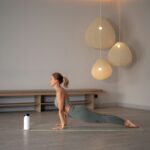 집에서도 충분한 건강 관리, ‘마이크로 워크아웃’ 열풍 확산 a woman doing yoga