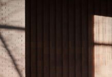 짧은 걷기, 꾸준한 실천… 일상 속 ‘움직임 건강법’ 인기 Woman walking past a brick building with shadows